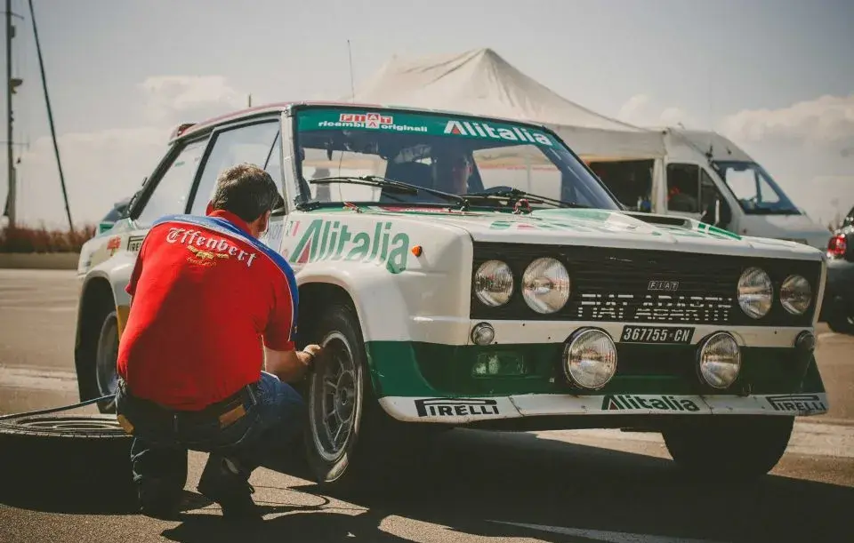 man touching the wheel of fiat abarth 131