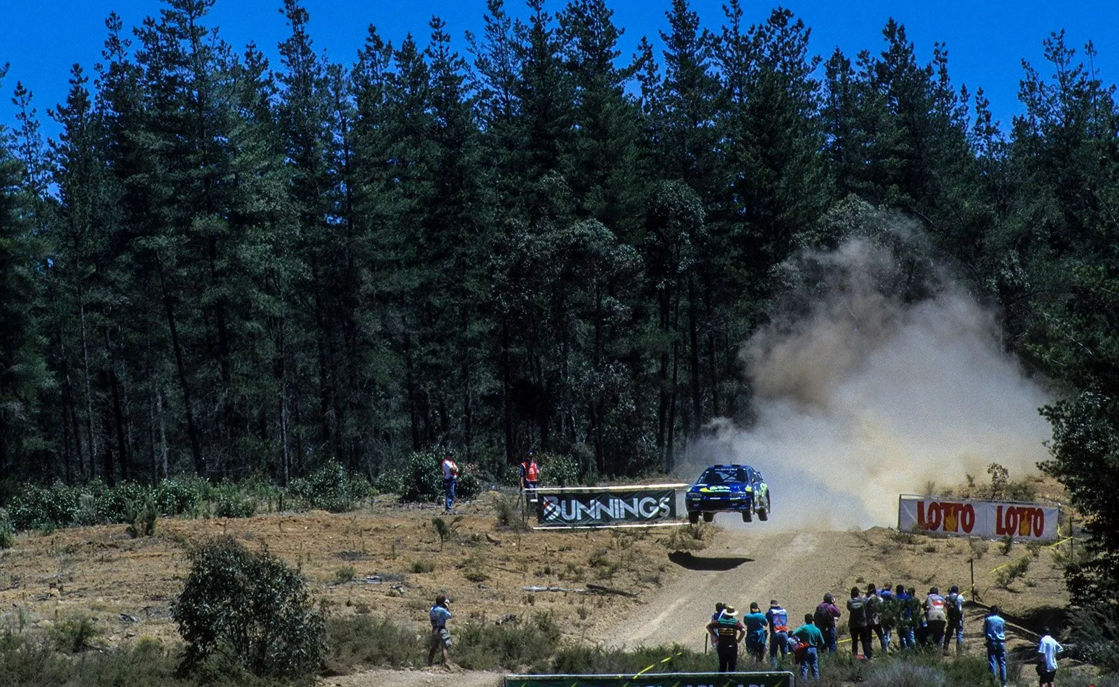 a blue subaru jumps on a road